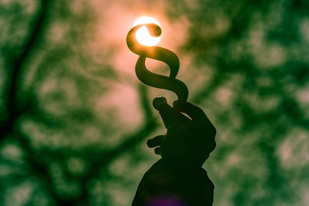 low-angle-view-hand-holding-silhouette-decoration-against-trees-sky
